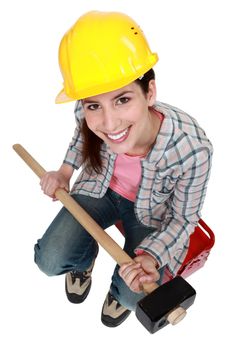 Woman with sledge-hammer sitting on tool box