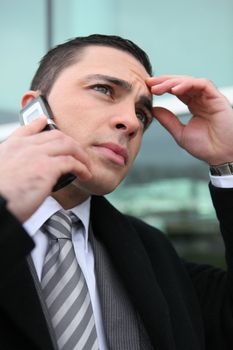 close-up shot of young businessman on the phone looking preoccupied