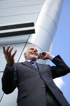 Senior businessman taking a call outdoors
