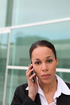 Serious businesswoman on phone outdoors