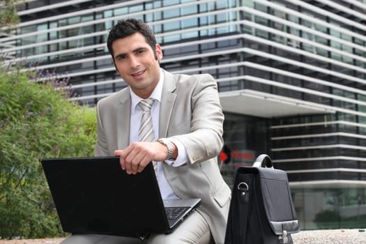 Young man using laptop outdoors