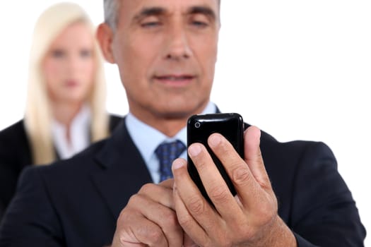 Older businessman texting on cellular phone