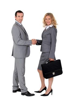 Smart suited man and woman shaking hands