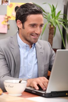 Man using his laptop during breakfast