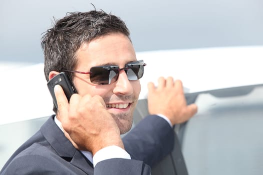 Elegant businessman on phone outdoors