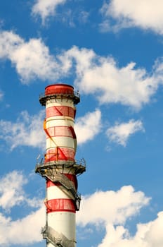 A power plant tower against a blue sky