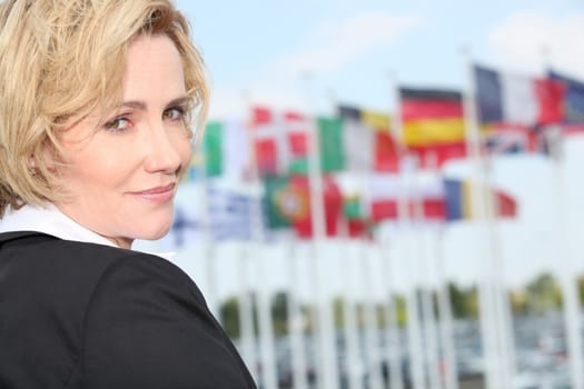 Businesswoman next to flags