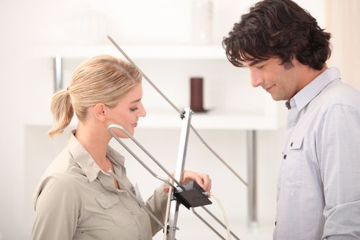 Couple installing television aerial