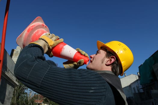 Man shouting into a traffic cone