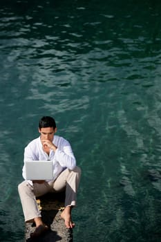 Businessman sat by water