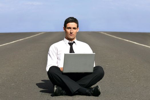 Man alone with laptop on airstrip