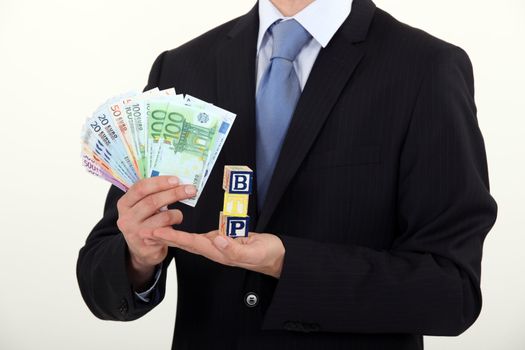 Man holding toy blocks and money