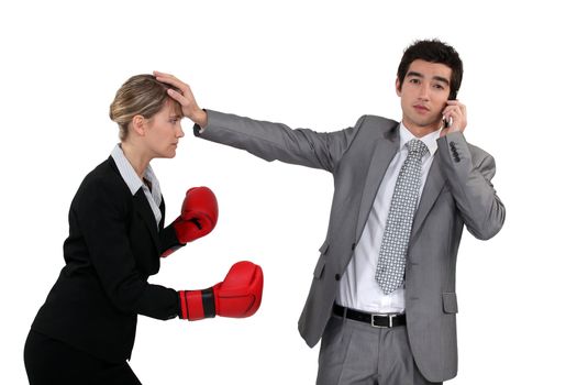 Woman with boxing gloves trying to hit woman