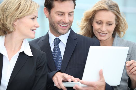 Business people looking at laptop