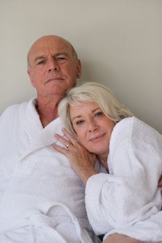 Retired couple sat in bathing robes