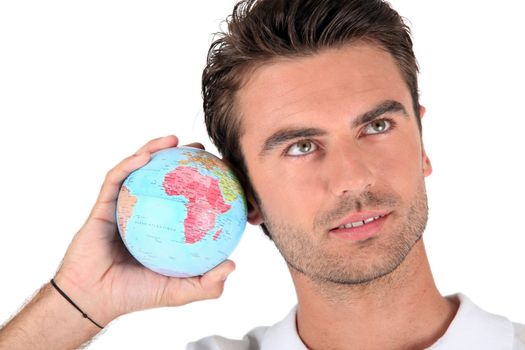Man listening into a globe