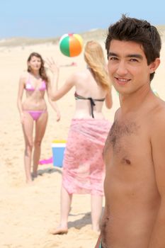 Three teenager playing with ball at the beach