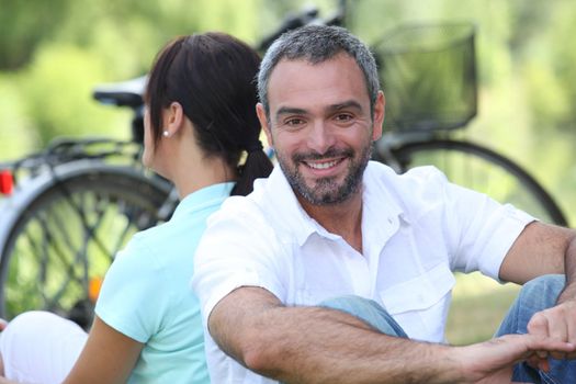 Couple sitting by their bikes in the countryside