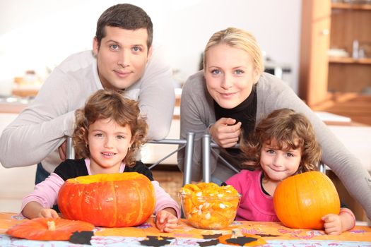 A family carving Halloween pumpkins.