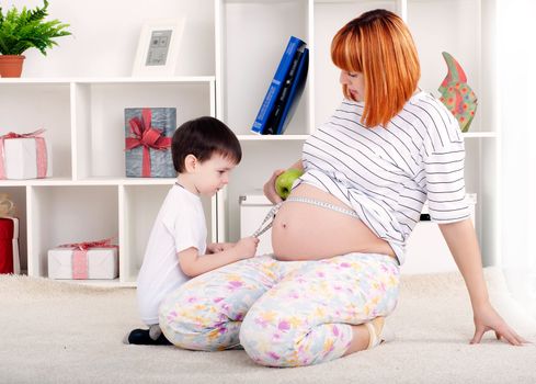 portrait of a pregnant woman and her son, at home