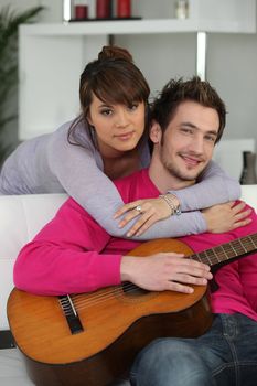Young couple indoors with a guitar