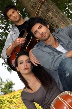 Musicians sitting by a tree