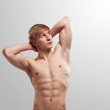 Handsome guy posing with naked torso over background