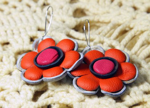 leather earrings in ethnic style on the knitted scarf