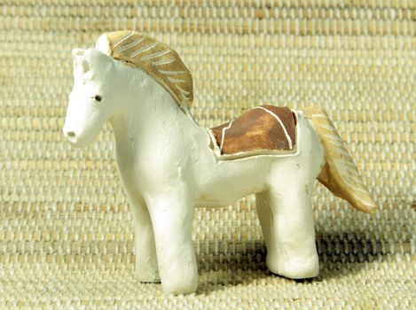 hand made clay ethnic horse on bamboo background
