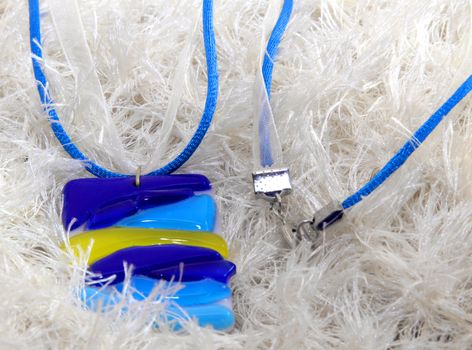 handmade necklace of blue glass flowers on white scarf