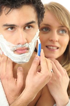 Young woman embracing her boyfriend while shaving