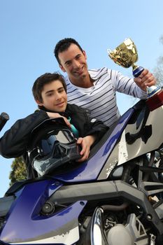 Father and son holding a trophy