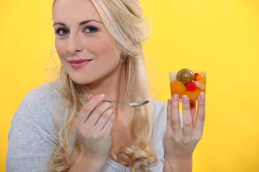 Blond female holding fruit cocktail