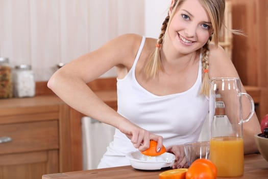 A blond pressing oranges.