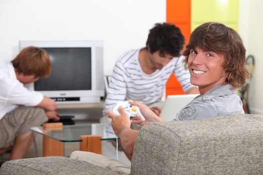 Three male teenagers relaxing at home