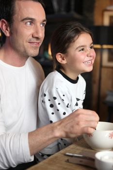 Father and daughter laughing at breakfast