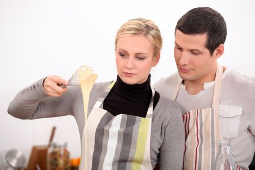 Young man and young woman making a cake dough