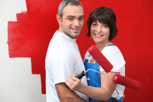 Couple painting a wall red