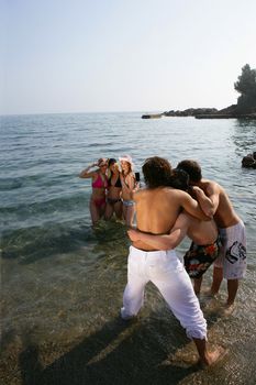 Friends taking holiday snaps in the sea