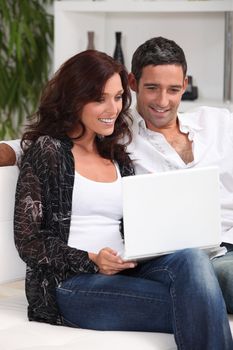 couple with laptop in lounge
