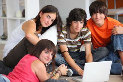 teenagers having fun with a laptop at home