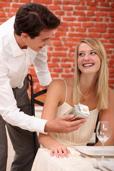Couple with a present in a restaurant