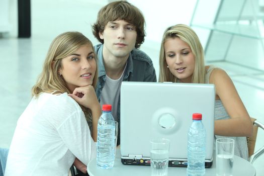 Teenagers sitting round a laptop computer