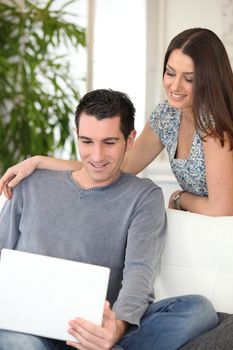 Couple at home watching laptop screen