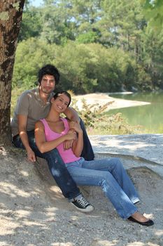 Happy couple sat under a tree