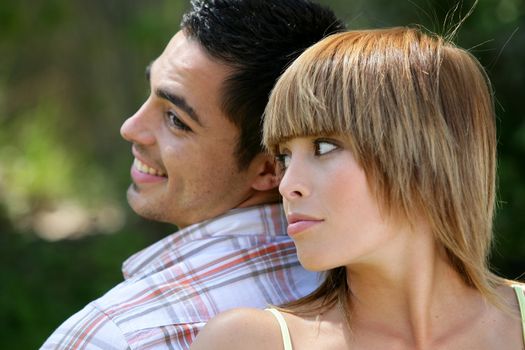 Couple stood back to back in field