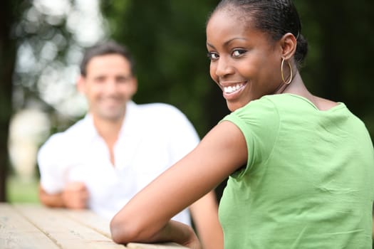 Young woman sitting at a table outdoors