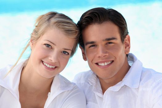 Smiling young couple sitting in the sunshine