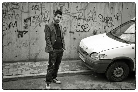 PROUD YOUNG MAN FATIH, ISTANBUL, TURKEY, APRIL 11, 2012: Proud young muslim man standing in front of his automobile in Fatih, Istanbul, Turkey asking for being captured.