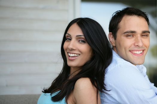 Couple sat outside house